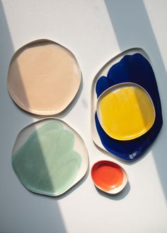 three plates with different colors on them sitting next to each other