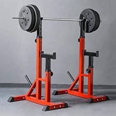 two squat stands with weight plates on each side and one holding a pair of barbells