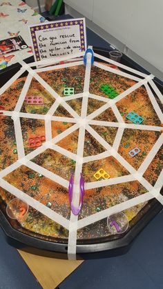 a close up of a game board on a table with paper and scissors in it