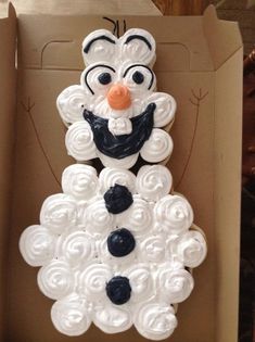 a cake in the shape of a snowman is on display at disney's art of animation