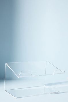 two clear acrylic boxes sitting side by side on a white table with a blue wall in the background