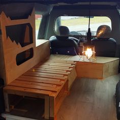 the inside of a van with a bed made out of wood