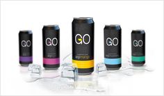 three cans of go energy drink with ice cubes around them on a white surface