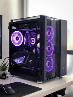 there is a computer with purple lights in the case on top of a desk next to a monitor and keyboard