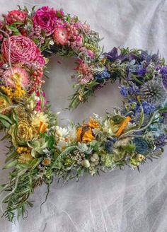 a wreath made out of flowers on a white sheet