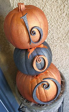 three pumpkins stacked on top of each other with the letter j painted on them