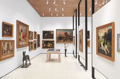 an art gallery with paintings and sculptures on the walls