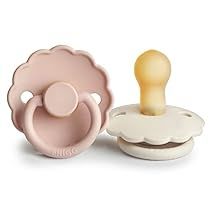 three baby pacifiers in different shapes and sizes, one with a dummy on top