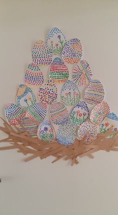 a bird nest with lots of colorful eggs in it