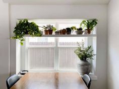 a wooden table topped with potted plants next to a window