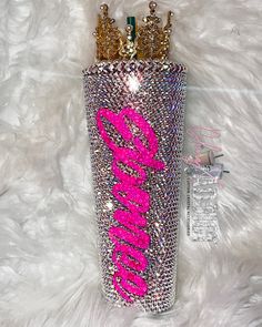 a pink and gold crown on top of a bottle