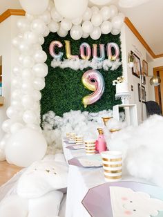 a party with balloons and decorations on the wall, including a giant cloud sign that says cloud 2