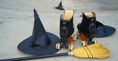 two black witches hats and one yellow broom are on the ground next to each other