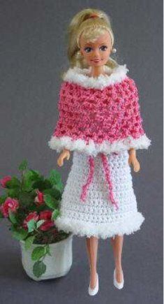 a crocheted doll is standing next to a potted plant with pink flowers