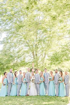 a group of people standing next to each other in front of a tree