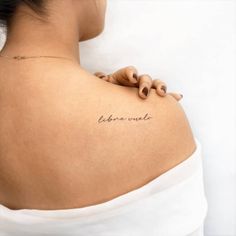 the back of a woman's left shoulder with writing on it that says, libero vie