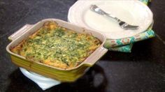 a casserole dish with spinach and cheese in it sitting on a table