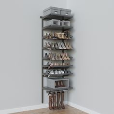 a shoe rack with several pairs of shoes on it and two boxes in the corner