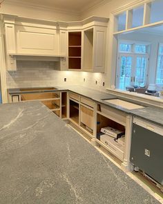 an empty kitchen with white cabinets and granite counter tops in the process of remodeling