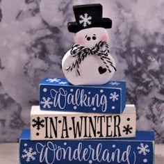 a snowman sitting on top of three stacked books that say walking in a winter wonderland