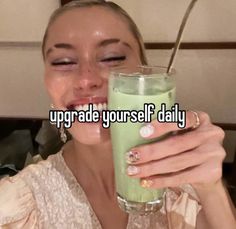 a woman drinking a green drink with the words upgrade yourself daily