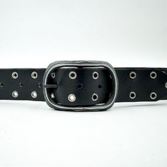 The Lee belt boasts sleek black Italian leather, a gunmetal center bar buckle, and eyelet detail, all sourced in Italy and skillfully handcrafted in the USA. Details: Black Italian leather Gunmetal center bar buckle Gunmetal eyelet detail Sourced in Italy Made in the USA Black Leather Belt With Edgy Style, Edgy Leather Belts With Belt Loops, Black Leather Belt Buckles With Antique Buckle, Black Leather Belt Buckle With Antique Design, Black Leather Belts With Rivets, Black Leather Belt With Rivets, Adjustable Black Belt Buckles With Rivets, Adjustable Leather Belt Buckle With Metal Buckle, Adjustable Black Belts With Rivets