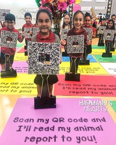 a group of children holding up their qr code and animal report to the camera