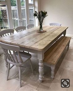 a wooden table with white chairs around it