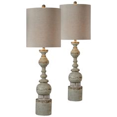 two lamps are sitting next to each other on a white surface with a beige shade