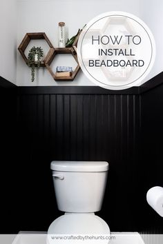 a white toilet sitting in a bathroom next to a black wall