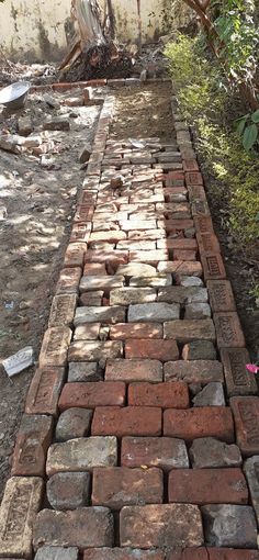 an old brick walkway is being built