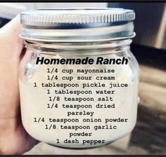 a hand holding a jar filled with homemade ranch