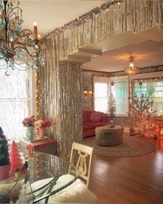 a living room filled with furniture and a chandelier hanging from the ceiling next to a window