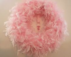 a pink feather wreath hanging on the wall