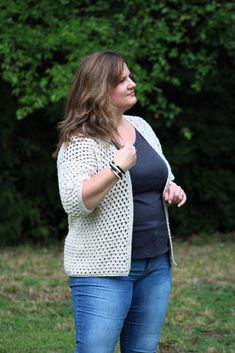 a woman standing in the grass with her hand on her hip