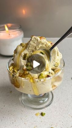 an ice cream sundae with nuts and pistachios in a glass dish