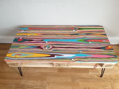 a multicolored wooden table sitting on top of a hard wood floor