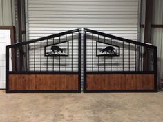 two metal gates with wooden panels in front of a garage