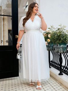 a woman in a white dress is standing on a porch with her hand on her hip