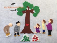 paper cut out people standing around a tree