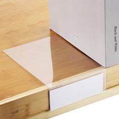 a book sitting on top of a wooden table next to a white box with writing on it