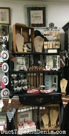 an assortment of necklaces on display in a room with wooden crates and other items