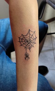 a spider web tattoo on the arm