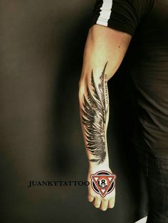 a man's arm with an angel wing tattoo on the left side of his arm