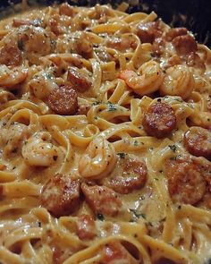 pasta with shrimp, sausage and sauce in a skillet