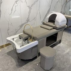 a bath room with a sink and a chair next to it on a marble floor