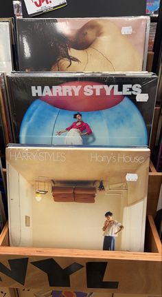 several records are stacked on top of each other in a store display case, with the covers pulled down