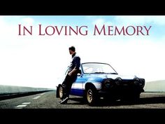 a man standing next to a blue car on the side of a road with words in loving memory