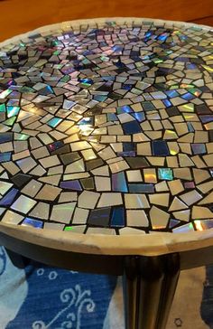 a mosaic table top sitting on top of a rug