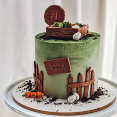 there is a green cake decorated with carrots and grass